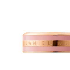 Close-up of the Emalie Ring in rose gold with a dusty rose enamel band and Daniel Wellington engraved detailing.
