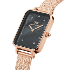 Rose gold women’s watch with a rectangular case, pressed piano link strap, and a black mother of pearl dial featuring crystal-set hour markers.