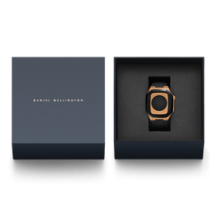 Switch Rose Gold Apple Watch case with black strap presented in an elegant navy Daniel Wellington gift box.