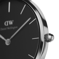 Detail of Petite Sterling women’s watch with black dial, slim silver markers, and polished stainless steel crown.