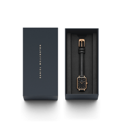Quadro Pressed Sheffield Black Rose Gold women’s watch with a black leather strap and rectangular black dial, elegantly presented in a dark Daniel Wellington gift box.