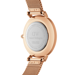 Back view of Daniel Wellington Petite Melrose watch showing engraved case and rose gold mesh strap with quick-release spring bars.