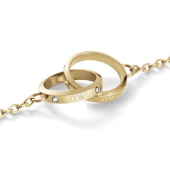 Close-up of the Classic Lumine Unity Gold necklace showing two interlocking polished gold circles with engraved initials and sparkling crystal accents on a fine chain.