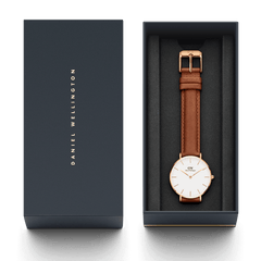 Daniel Wellington Petite Durham Rose Gold watch with a light brown leather strap presented in an elegant dark gift box.