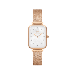 Rectangular rose gold women’s watch with a pressed piano link strap, featuring a white mother of pearl dial and crystal hour markers.