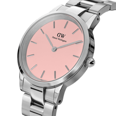 Close-up of the Daniel Wellington Iconic Link Blush watch showing its pastel pink dial, minimalist silver markers, and polished stainless steel bracelet.