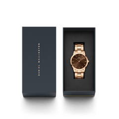 Daniel Wellington Iconic Link Amber watch with a rose gold bracelet and brown sunray dial, presented in an elegant branded gift box.