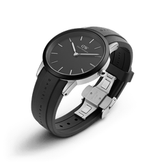 Daniel Wellington Iconic Motion watch with a black dial, minimalist silver markers, and a black FKM rubber strap featuring an engraved logo and stainless steel deployment clasp.