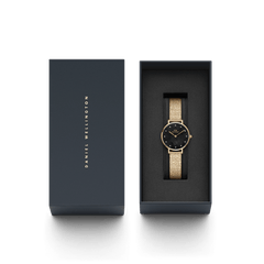 Petite Lumine Pressed Piano Gold women’s watch with black dial in Daniel Wellington gift box, gold mesh strap visible.