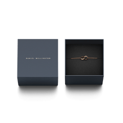 Classic Unity Lumine rose gold bracelet with intertwined rings and crystal accents, elegantly presented in a navy Daniel Wellington gift box.
