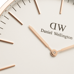 Close-up of the Classic Glasgow Rose Gold watch face, showing rose gold hands and hour markers on an eggshell white dial with Daniel Wellington branding.