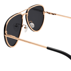 Close-up of Avion Steel Rose Gold sunglasses highlighting the rose gold stainless steel frame, black lenses, adjustable silicone nose pads, and engraved Daniel Wellington branding on the arm.