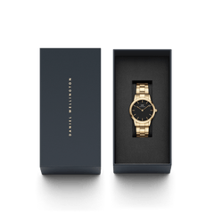 Iconic Link Gold women’s watch with black dial in Daniel Wellington gift box, gold-plated stainless steel bracelet visible.