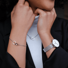 Woman wearing the Daniel Wellington Elan Unity Bracelet with interlocking silver rings, styled alongside a matching necklace and a silver mesh watch for a sophisticated look.