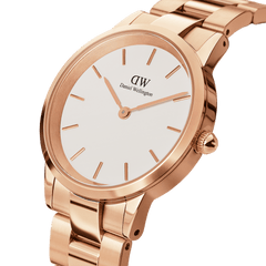 Close-up of the Daniel Wellington Iconic Link Rose Gold watch showing its polished rose gold stainless steel bracelet and minimalist eggshell white dial with gold hour markers.