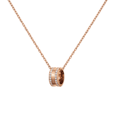 Rose gold necklace featuring a delicate cable chain and a round barrel pendant set with sparkling crystals and engraved detailing.