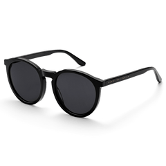 Sleek black round sunglasses with a polished bio-acetate frame, dark lenses, and subtle gold Daniel Wellington branding on the arms.