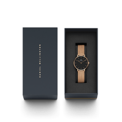 Daniel Wellington Petite Melrose watch with black dial and rose gold mesh strap presented in a sleek branded gift box.