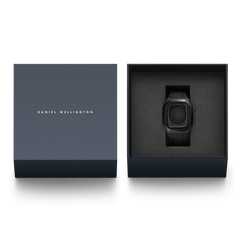 Switch Black Black Daniel Wellington Apple Watch case with black rubber strap, elegantly presented in a signature navy blue gift box.