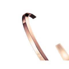 Close-up of Daniel Wellington Classic Bracelet in rose gold, showing polished finish and subtle engraved logo detail.