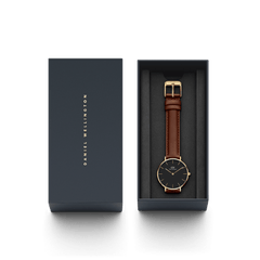 Daniel Wellington Petite St Mawes Gold watch with brown leather strap in gift box, elegant black and gold packaging.