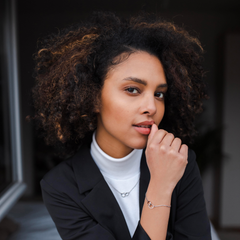 Person wearing the Daniel Wellington Elan Unity Bracelet with interlocking silver rings and a matching necklace, styled with a black blazer and white top for a modern, elegant look.