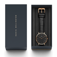 Classic Reading Black Rose Gold watch with a black croc-embossed leather strap presented in a signature Daniel Wellington gift box.