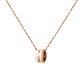 Rose gold necklace with a delicate chain and a satin white enamel ring pendant engraved with subtle branding.