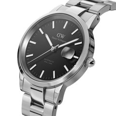 Close-up of the Iconic Link Automatic men’s watch featuring a polished stainless steel bracelet, minimalist black dial, luminous hands, and a prominent magnified date window.