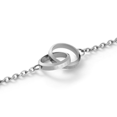 Close-up of the Daniel Wellington Elan Unity Bracelet showing two polished silver interlocking rings with subtle engraving on a fine chain.