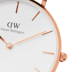 Detail of Daniel Wellington Petite St Mawes Rose Gold watch with minimalist white dial and slim rose gold hands and markers.