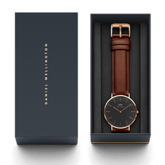 Classic St Mawes watch with a black dial, rose gold case, and brown leather strap presented in an elegant Daniel Wellington gift box.