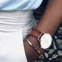 Classic St Mawes Rose Gold watch with brown leather strap, styled on wrist with rose gold bracelet and smart casual outfit.