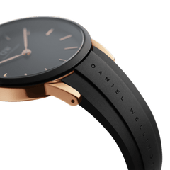 Close-up of Iconic Motion Rose Gold women’s watch showing black rubber strap with Daniel Wellington branding and rose gold case.