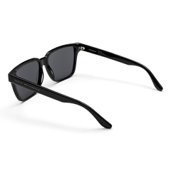 Rectangular Bio-Acetate Black sunglasses with deep black frames, dark lenses, and gold Daniel Wellington branding along the arms.