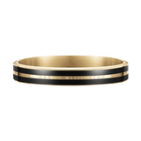 Polished gold and black Daniel Wellington bangle featuring two sleek enamel ribbons and subtle brand engraving, designed with a seamless, modern silhouette.